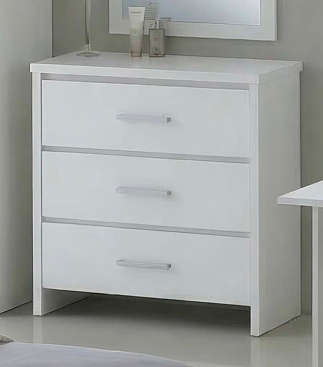 A white three-drawer dresser with slim silver handles, shown in a minimalist bedroom setting with a mirror and bedside table partially visible.