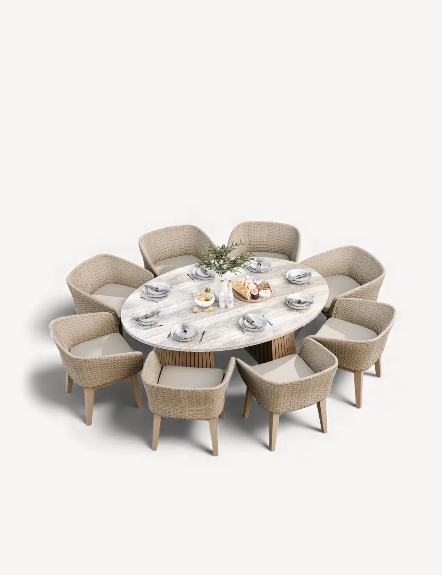 Oval dining table with light wood top and eight wicker armchairs, tableware set for eight