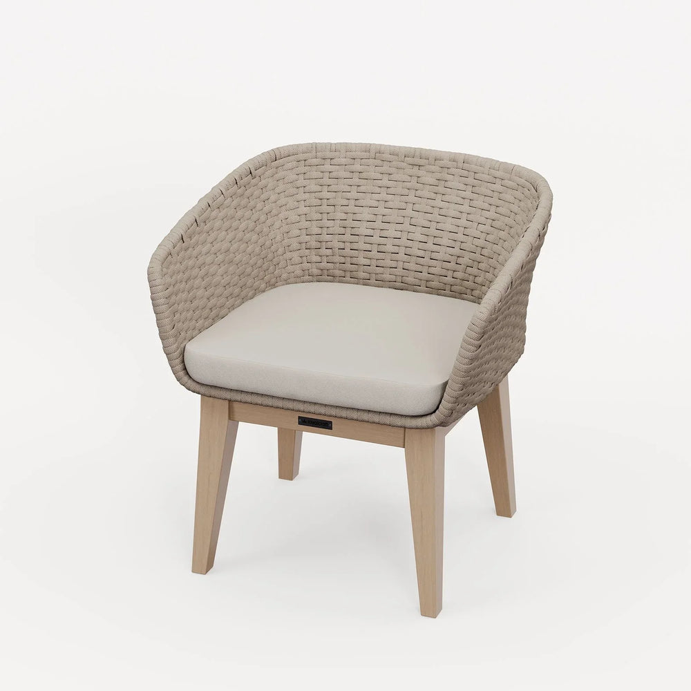 Rattan dining chair with light wood legs and beige cushion on white background