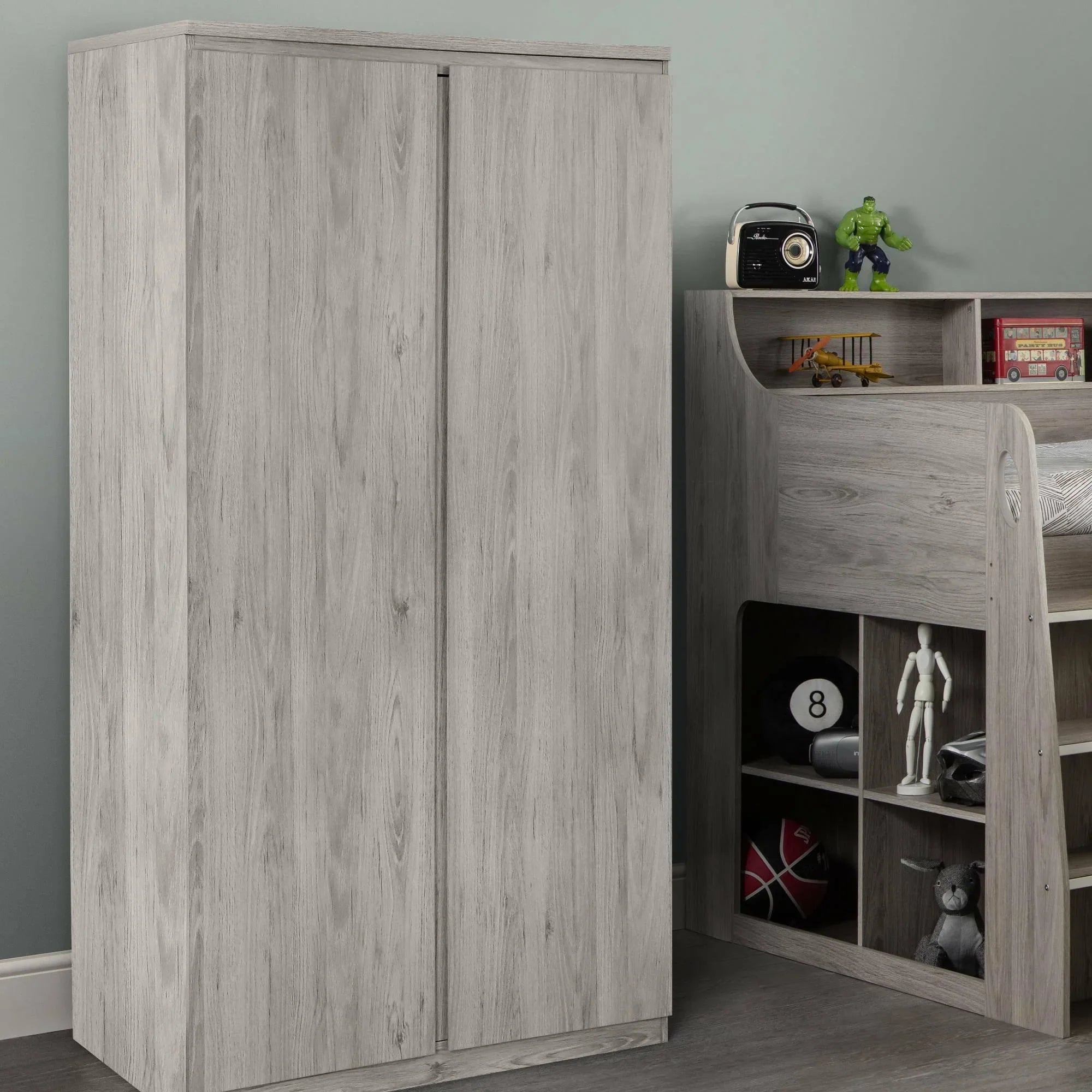 Grey oak 2 door wardrobe beside matching storage bed in modern room