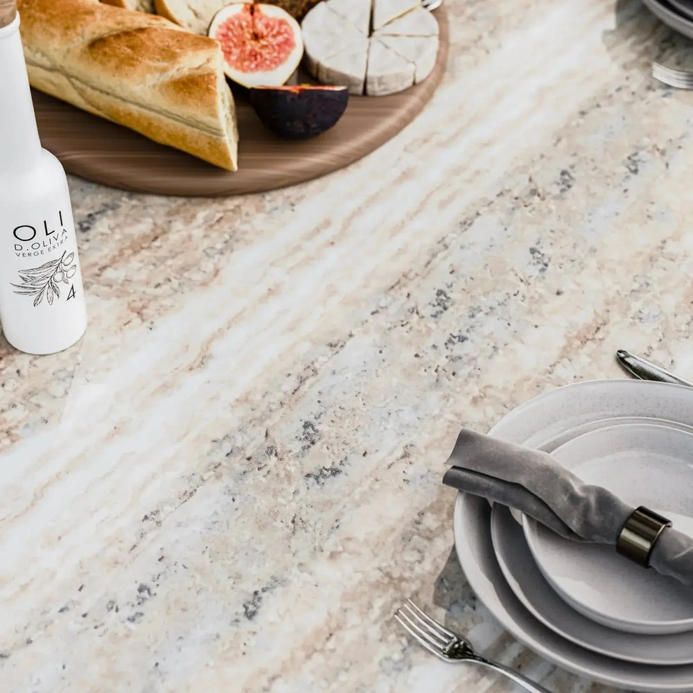Marble dining table with place setting, bread, cheese, figs, and bottle of olive oil