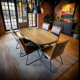 Walnut dining table with six cognac leather chairs in modern loft dining room