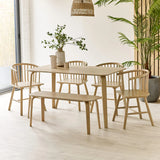 Light wood dining table set with four spindle back chairs and bench in bright modern room