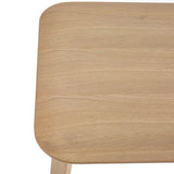 Closeup of light oak dining table corner showing wood grain and rounded edge