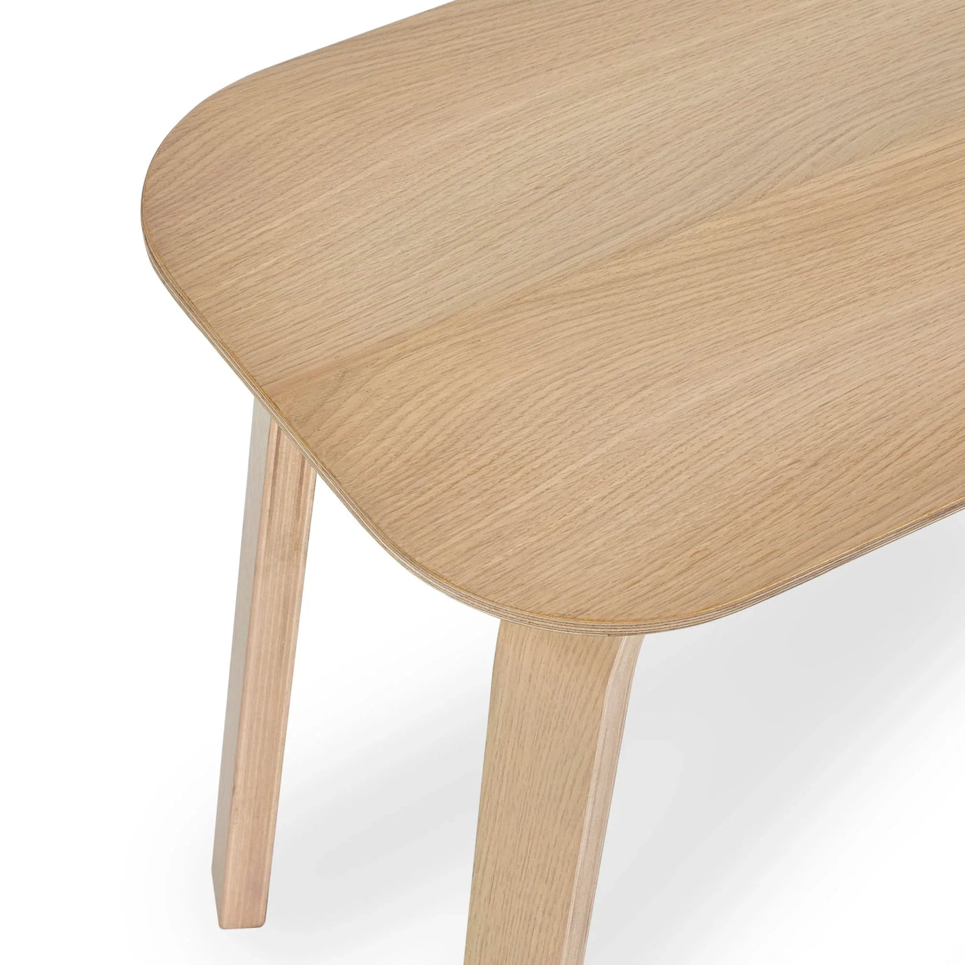 Oak dining table corner with rounded edge and light wood grain finish