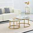 A modern nesting coffee table set with round white marble tops and gold-finished metal bases, styled in a bright living room next to a cream sofa.