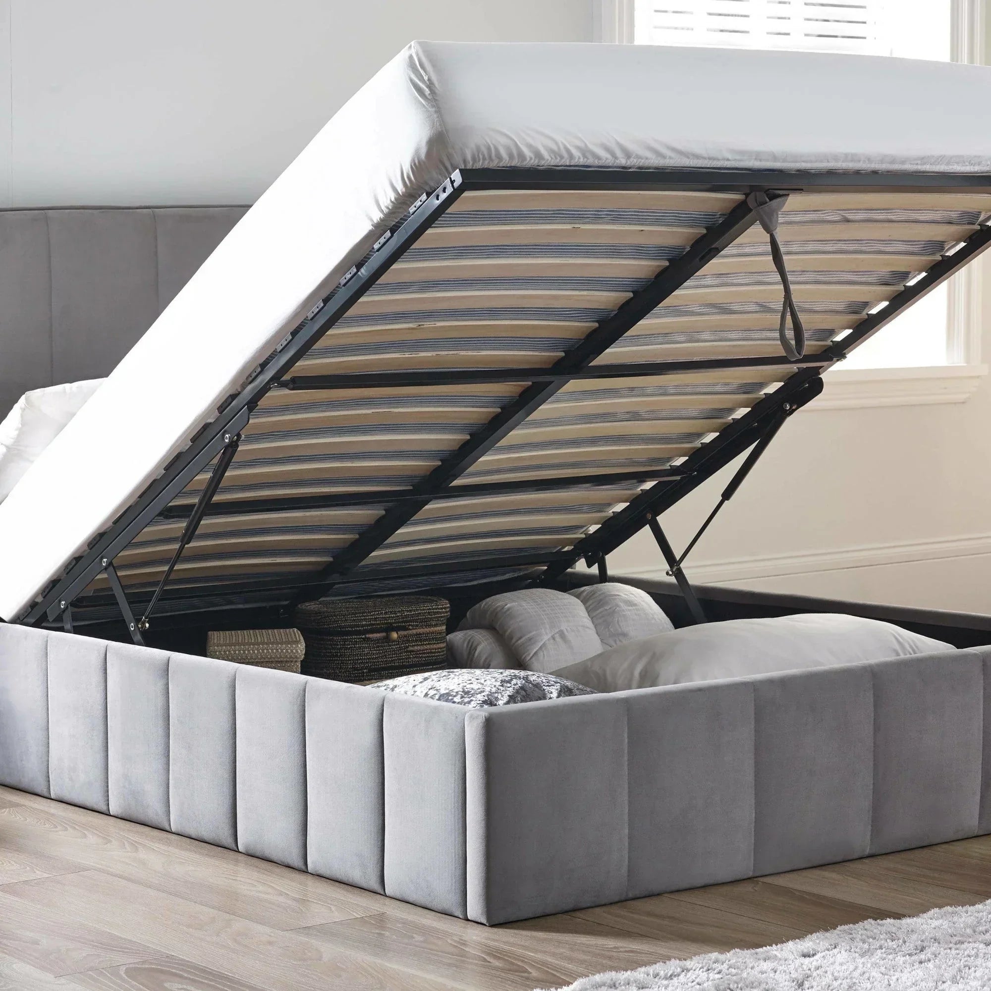 Grey ottoman storage bed frame with mattress lifted to show underbed storage space