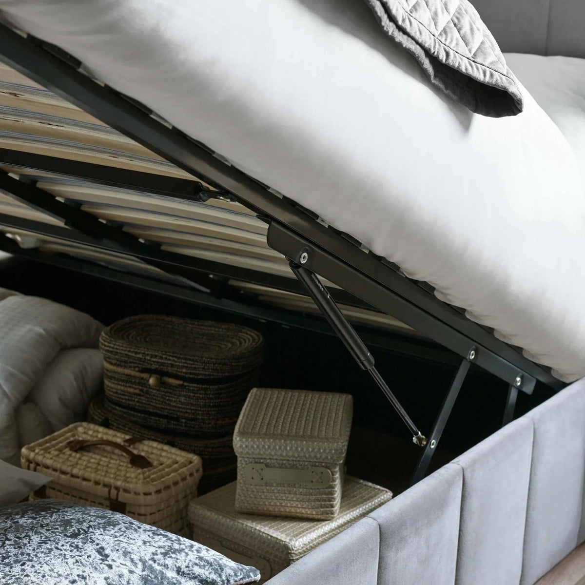 grey ottoman storage bed frame with open lift mechanism showing storage baskets inside