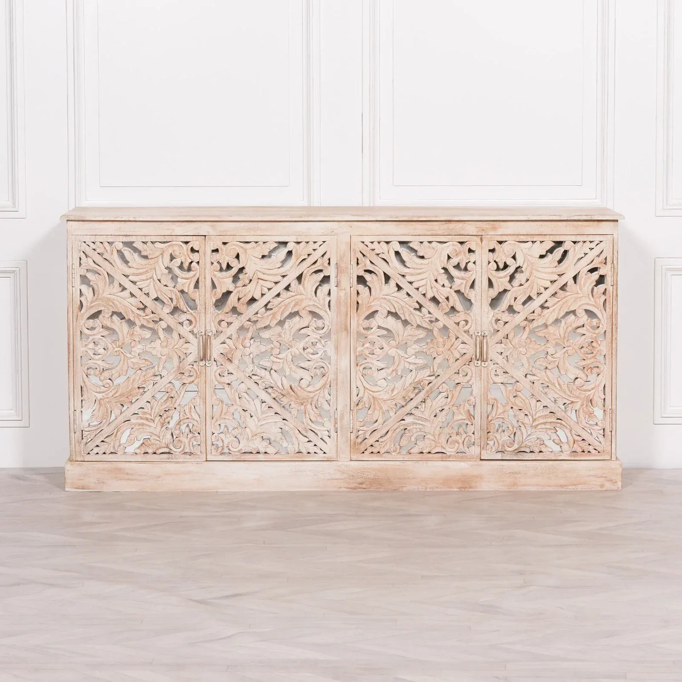 Carved wooden sideboard with floral detailing and natural finish against white paneled wall