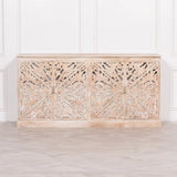 Carved wooden sideboard with floral detailing and natural finish against white paneled wall