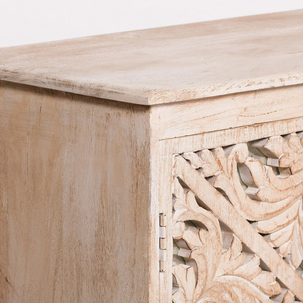 Light wood cabinet corner with carved floral patterned door panel