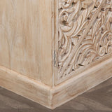 Corner of carved wooden cabinet with floral pattern and natural light wood finish