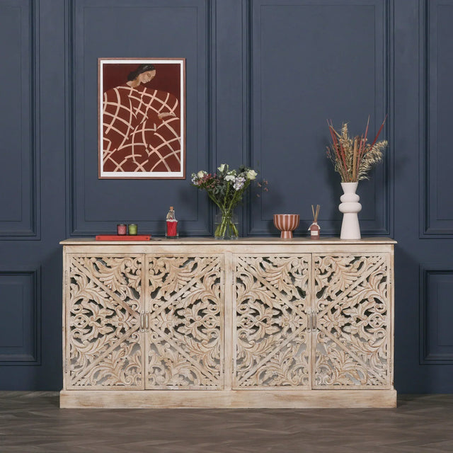Carved wood sideboard with floral pattern, rustic finish, decorated with vases and flowers