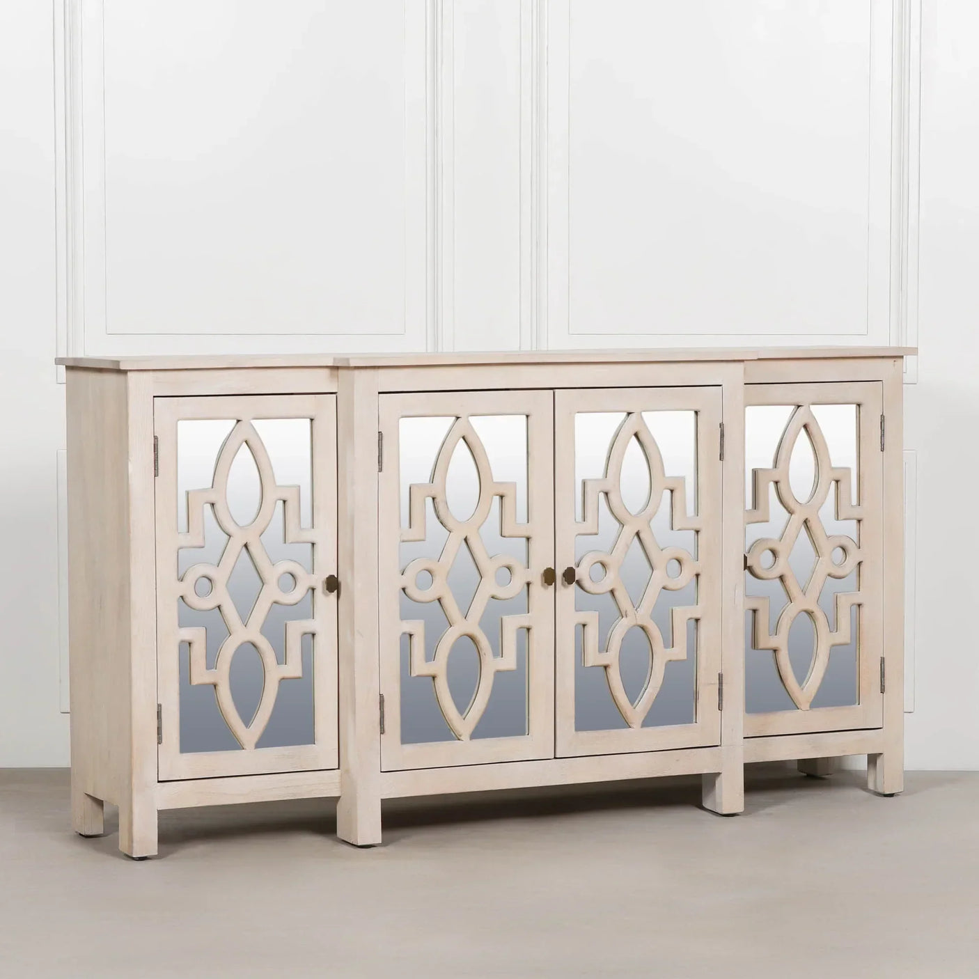 Light wood sideboard cabinet with mirrored geometric panel doors against white wall