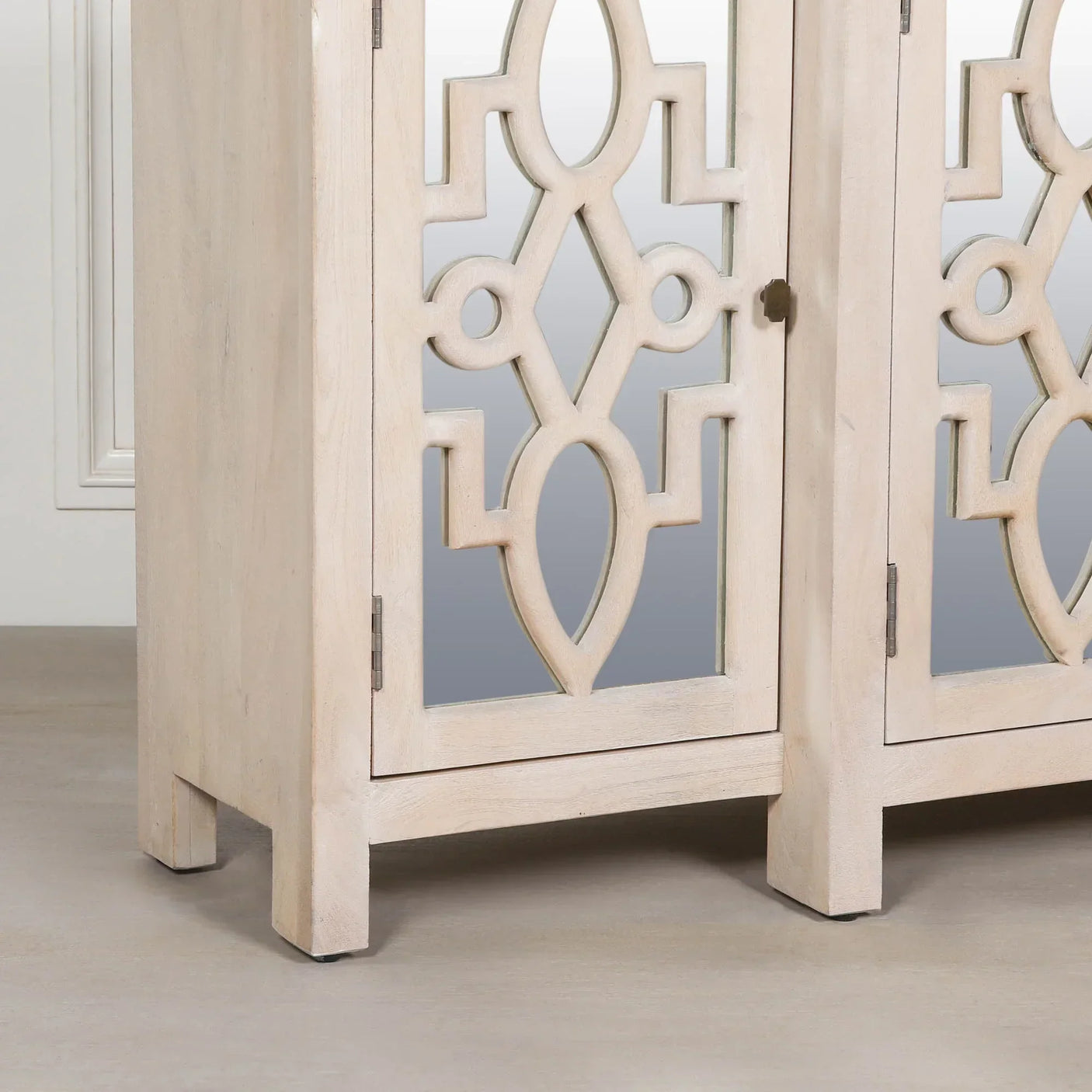 Light wood cabinet with mirrored door and geometric carved panel detail, front angle view