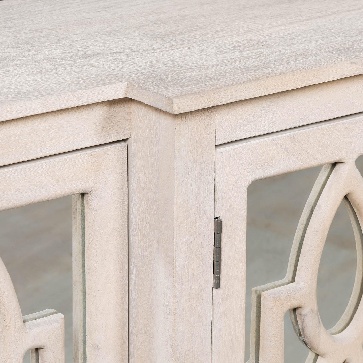 Light wood sideboard corner with carved mirrored door detail and matte finish