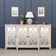 Mirrored sideboard with geometric wood doors, decorative lamp and plant on top