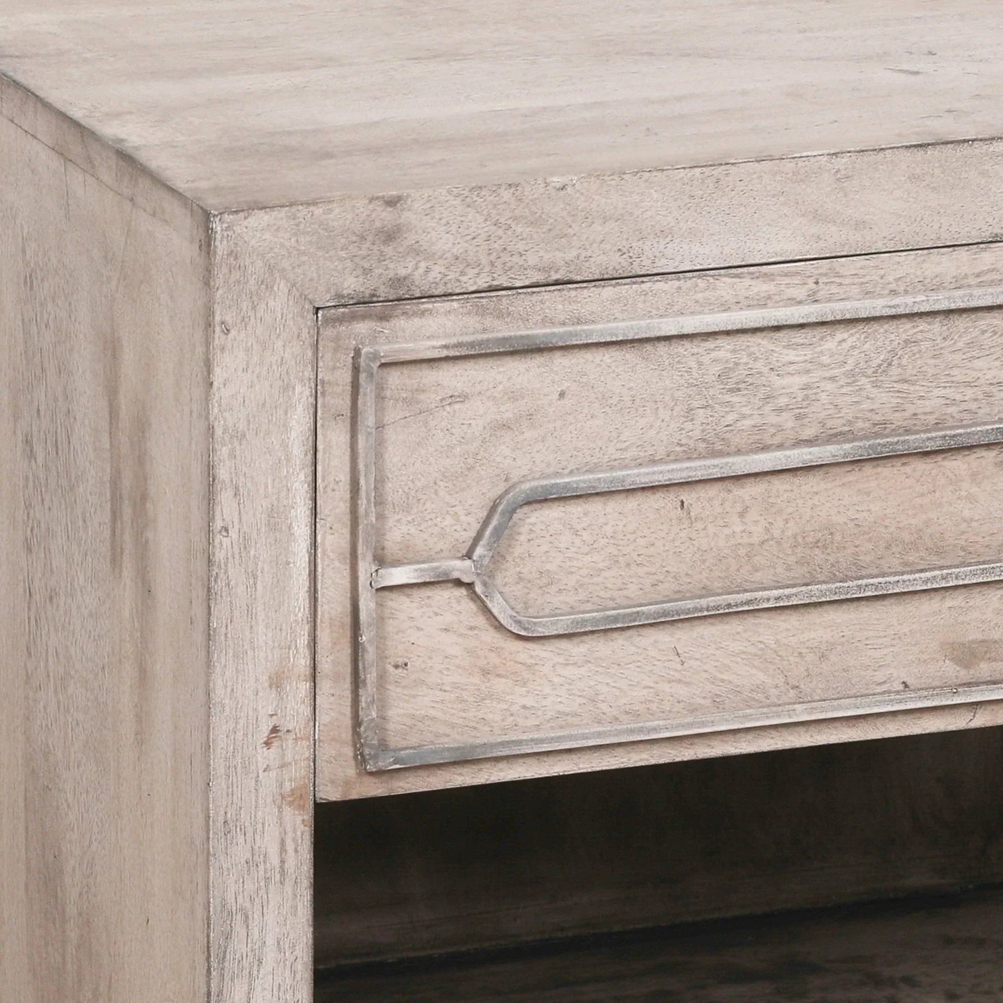 Light wood bedside table corner showing drawer with metal trim detail