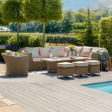 Rattan garden furniture set with beige cushions and dining table by pool on patio