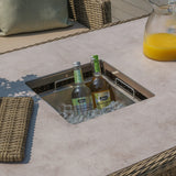 Outdoor rattan garden table with built-in ice bucket holding drinks and a jug of juice