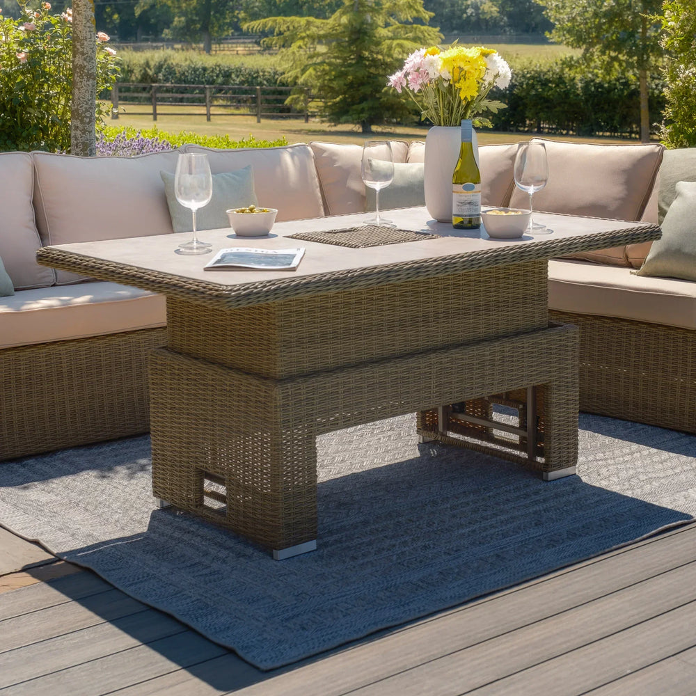 Rattan garden sofa set with cream cushions and glass top table on wooden patio