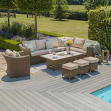 Rattan outdoor corner sofa set with beige cushions, coffee table, stools and garden view