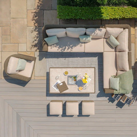 Rattan outdoor corner sofa set with beige cushions, armchair, stools and coffee table on patio
