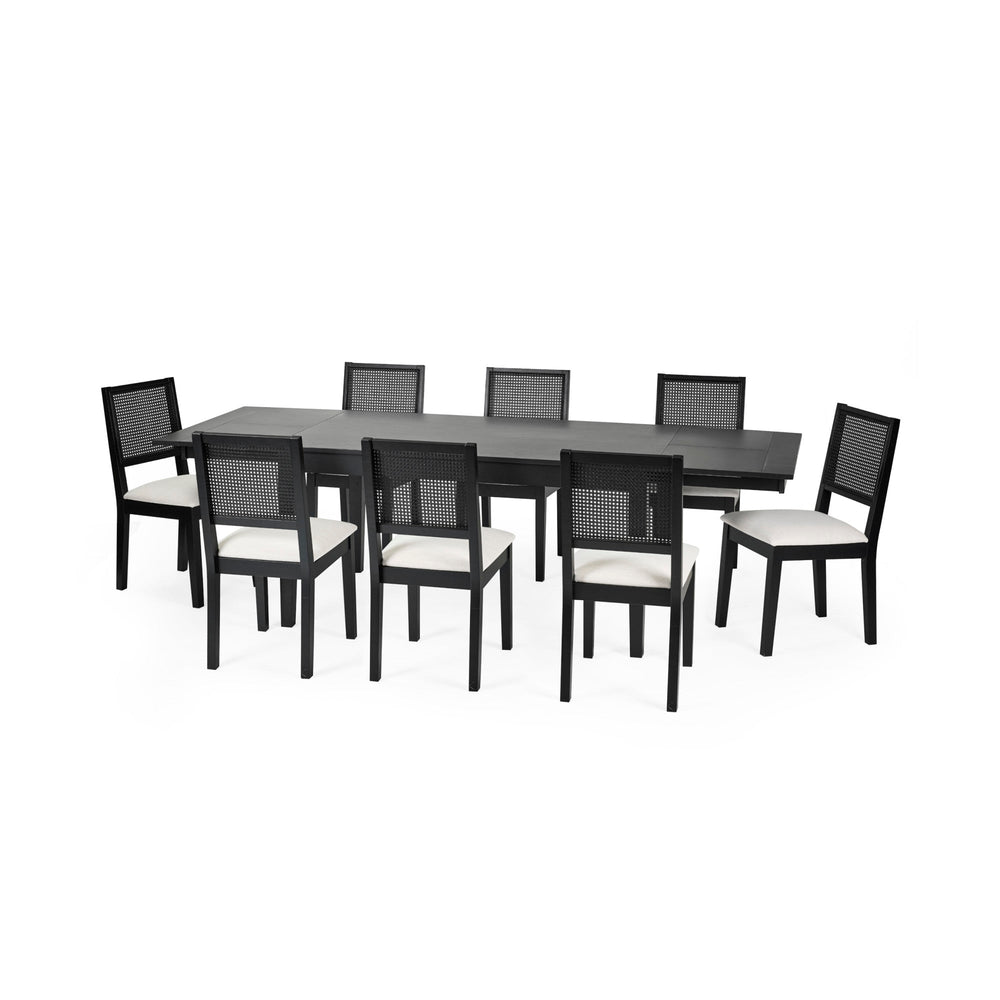 Larger black extending rectangular dining table with eight black chairs with white cushions and woven backrest