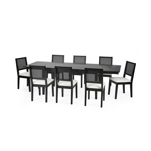 Larger black extending rectangular dining table with eight black chairs with white cushions and woven backrest