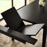 Close-up of black dining table leg and apron, showing square tapered design and smooth finish