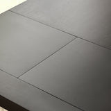 Close-up of extension panel seam on black wooden dining table top revealing wood texture