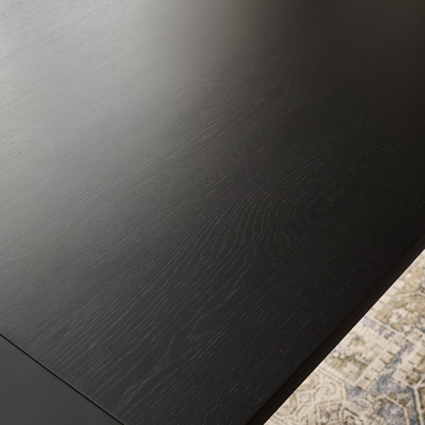 Close-up of black wood grain rectangular table surface with clear texture and corner edge visible