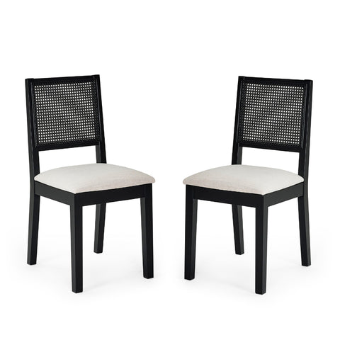 Pair of black wood dining chairs with woven cane backs and beige upholstered seats on white background.