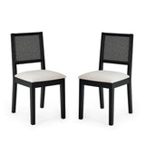 Pair of black wood dining chairs with woven cane backs and beige upholstered seats on white background.