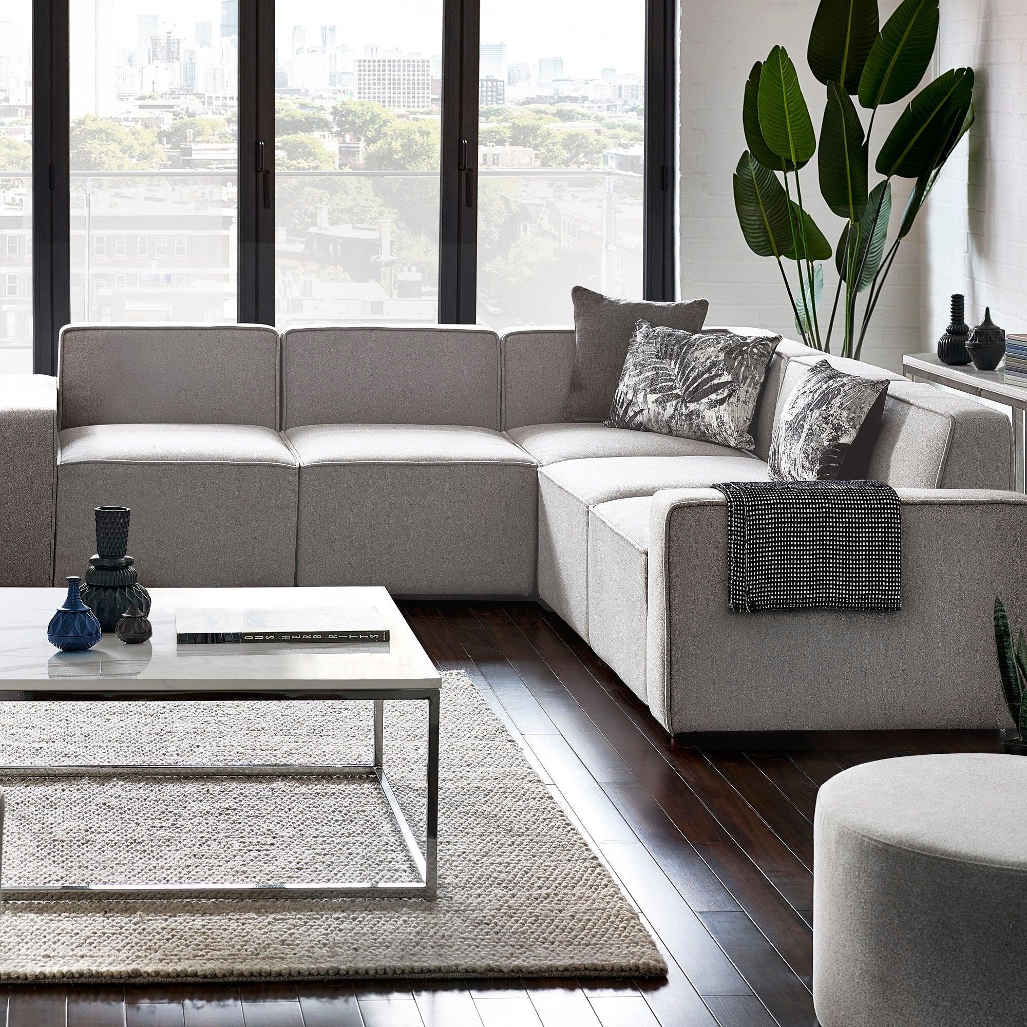 Grey fabric combi sofa set in modern living room with dark floor, coffee table, and cushions
