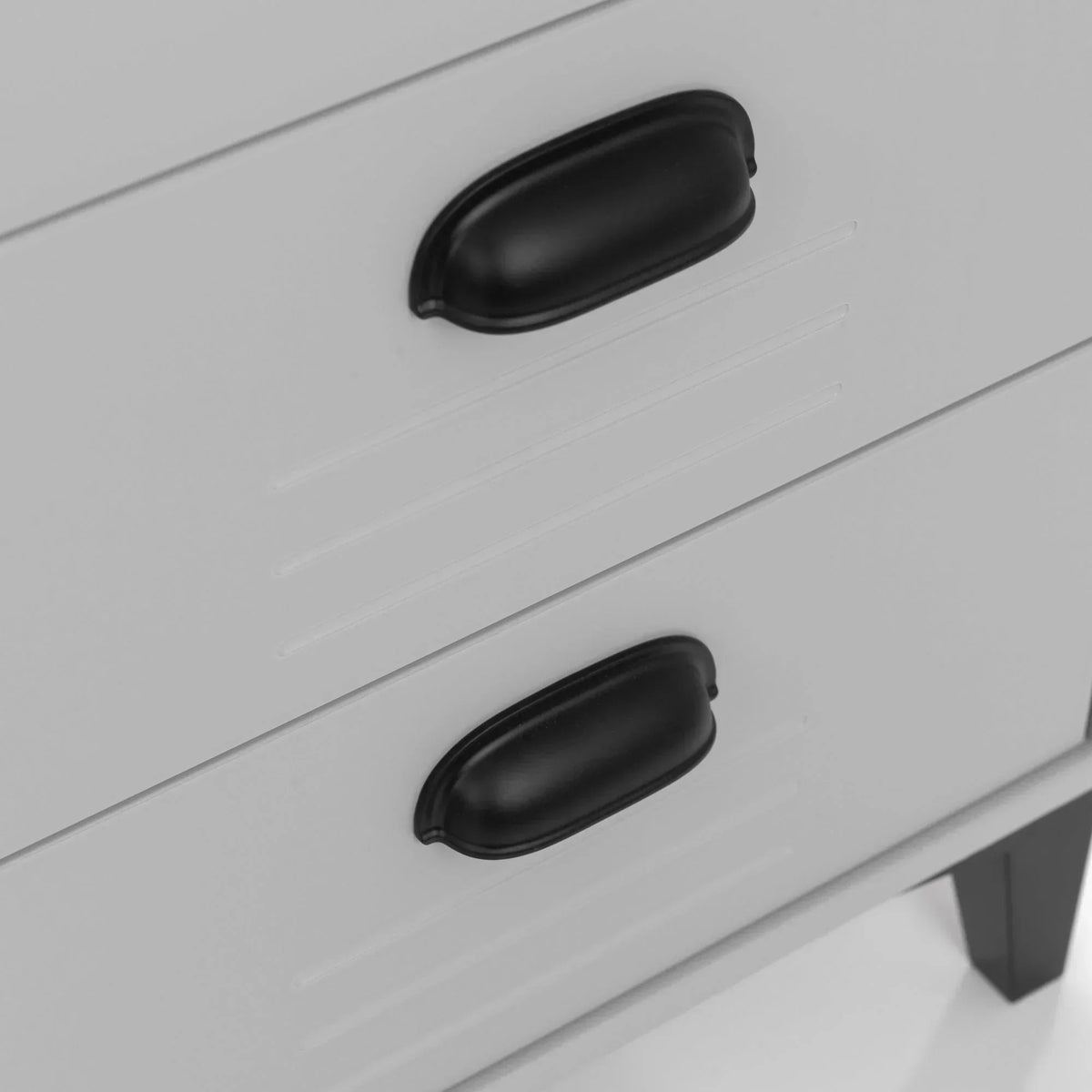 Drawer chest close-up with black metal handles and white finish