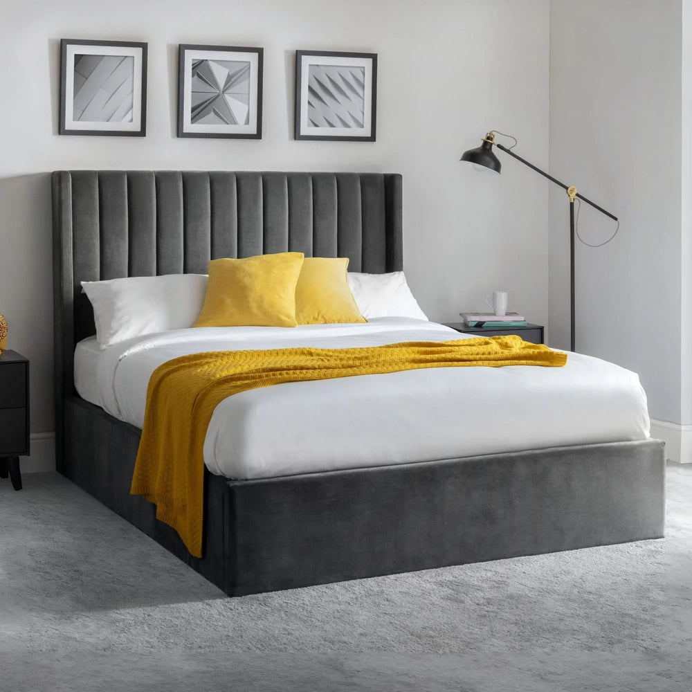 Grey velvet ottoman bed with high headboard, white bedding and yellow throw in modern bedroom