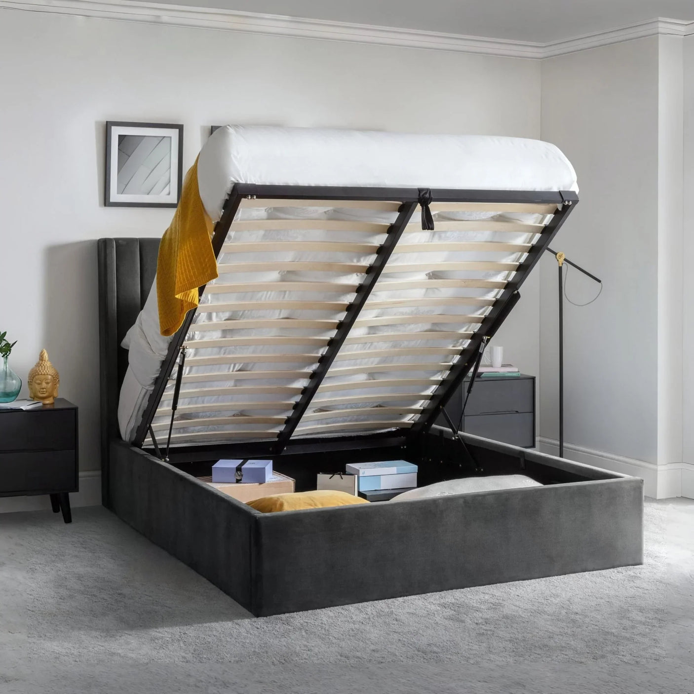 Grey ottoman storage bed with lifted frame showing underbed storage and bedroom décor
