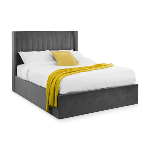Grey upholstered bed frame with paneled headboard, white bedding, yellow throw and pillow