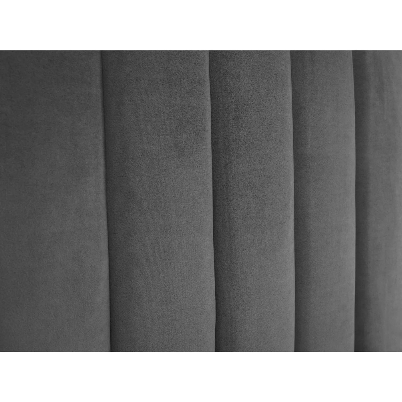 Close up of grey velvet upholstered bed headboard with vertical panel detailing