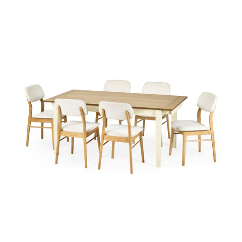 Dining table with cream legs and natural wood top surrounded by six wooden chairs with white cushioned seats.