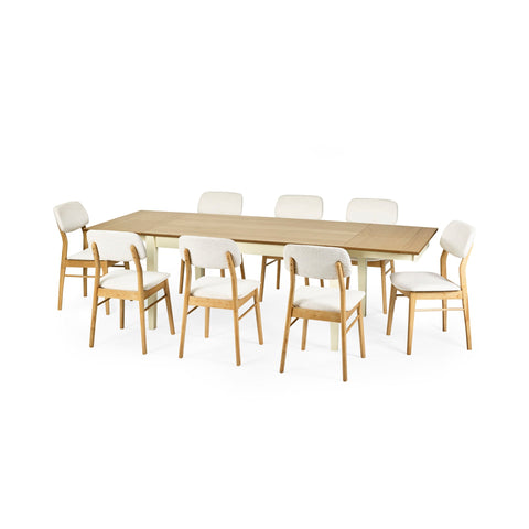 Extended rectangular dining table with cream legs and natural wood top surrounded by eight cushioned wooden chairs.