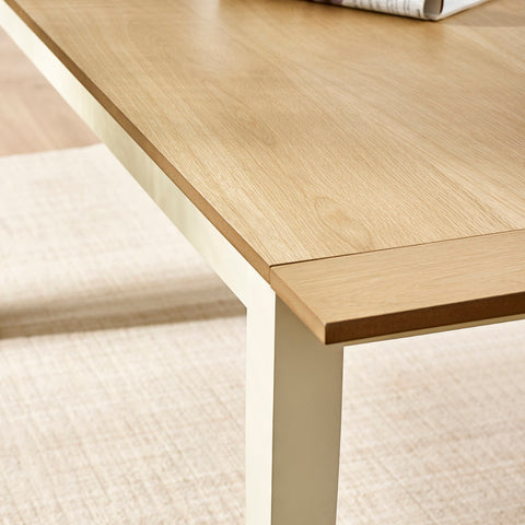 Inset detail of table edge showing cream leg and light wood top with extension panel slightly pulled out