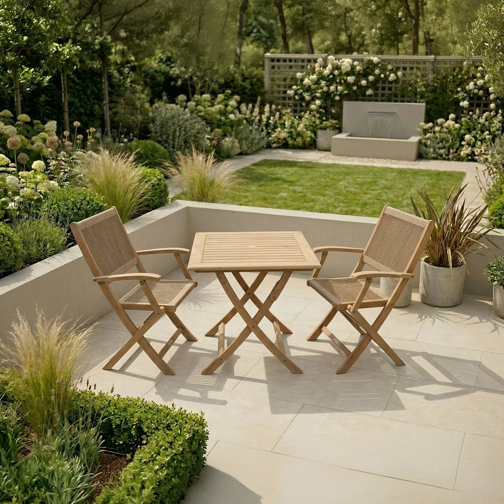 Teak garden dining set with two chairs on tiled patio surrounded by landscaped greenery