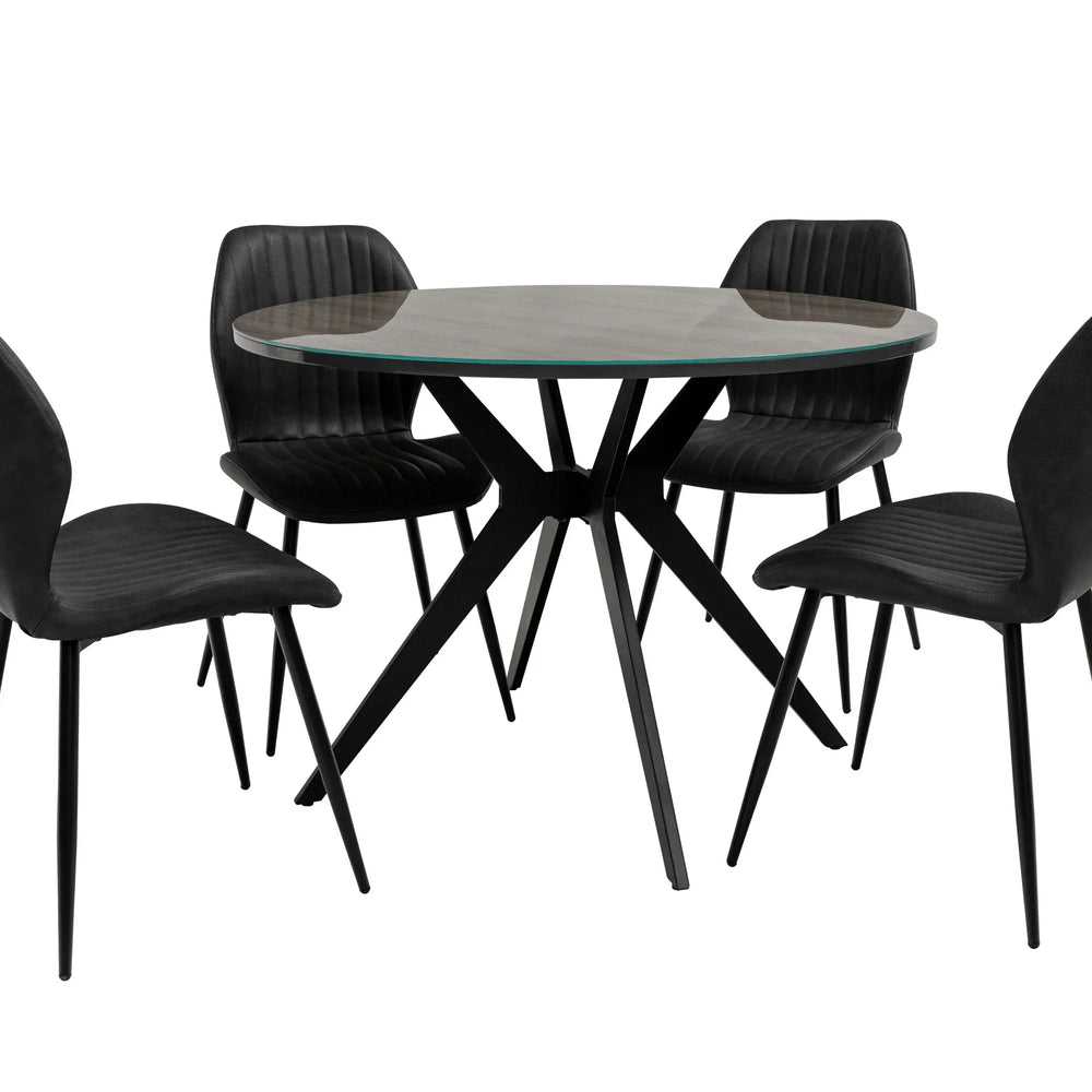Round glass dining table with black metal legs and four matching black upholstered chairs