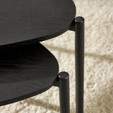 Close-up detail showing connection between black wood table tops and matte black metal legs
