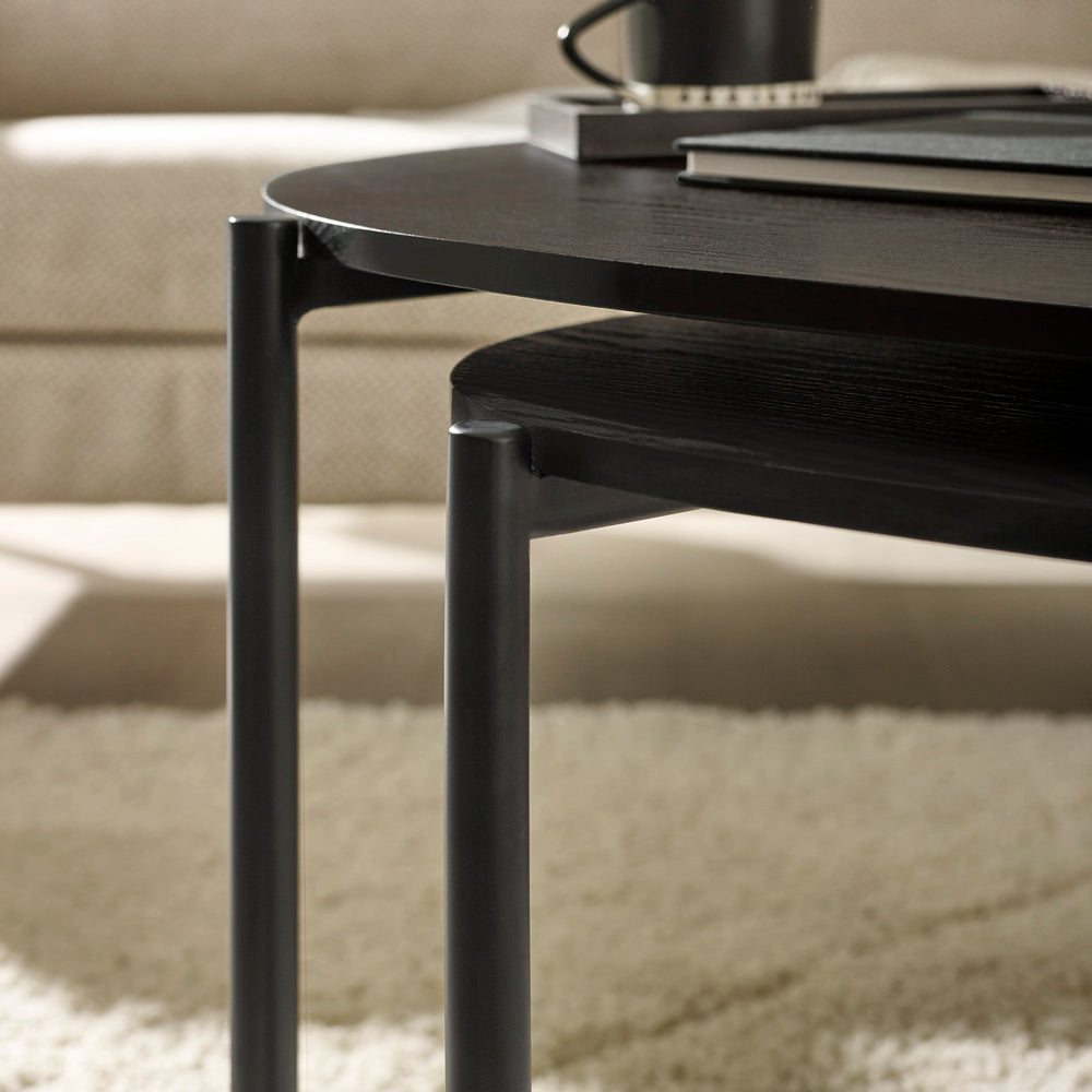 Top view of black wood teardrop nesting coffee tables showing wood grain and sleek edges
