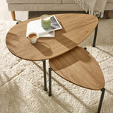 Close side angle of light oak nesting tables partially overlapped with black metal legs visible.
