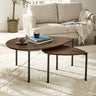 Dark wood nesting teardrop coffee tables with black metal legs in living room on light rug