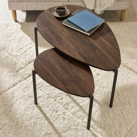 Two teardrop wooden nesting coffee tables with dark wood top, black legs, on textured cream carpet